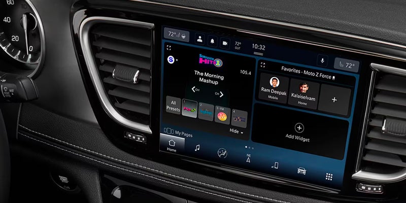 Close-up of a modern vehicle infotainment display showing media, navigation, and connected app features