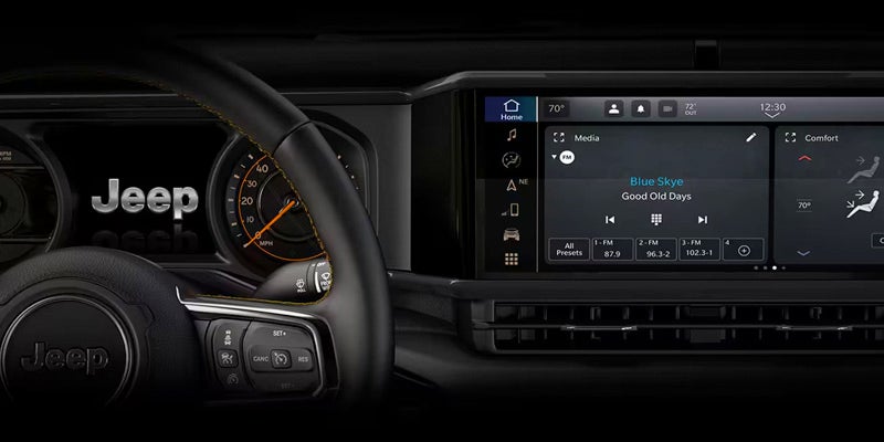 Steering wheel and digital dashboard interface displaying music, interior climate, and vehicle settings.