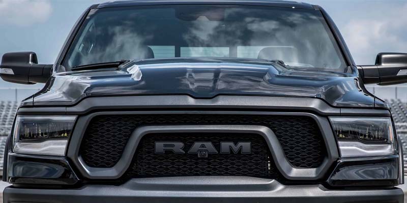 Front view of a dark gray Ram truck, showing its grille with 'RAM' logo, headlights, and part of the hood.