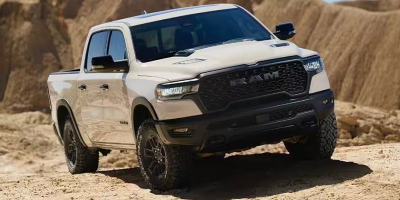 White Ram TRX pickup truck in the desert, angled with wheels in dips of the sandy terrain.