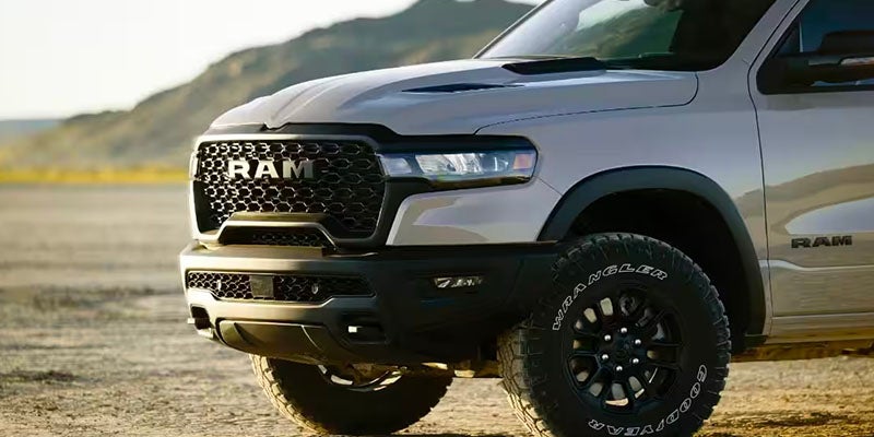 Front quarter view of a gray Ram truck with black grille, bumper, and off-road tires.