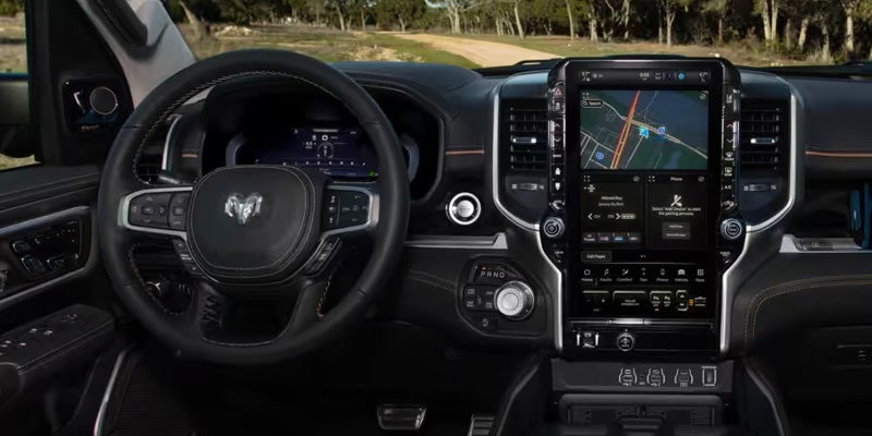 Interior view of a modern truck dashboard with a large central touchscreen displaying a GPS map and infotainment.